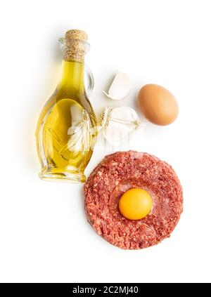 Bistecca di manzo tartare, tuorlo, aglio e olio isolato su sfondo bianco. Foto Stock