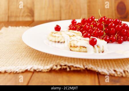 Dolci di ricotta e frutti di bosco freschi ribes rosso sulla piastra Foto Stock