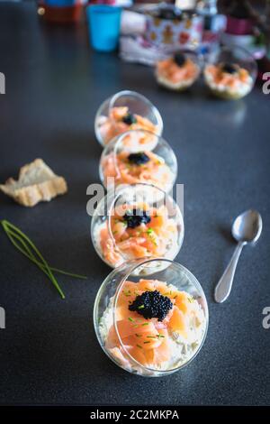 Salmone verrine ciclottero uovo formaggio fresco e letto di avocado in cucina Foto Stock