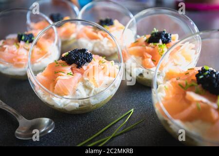 Salmone verrine ciclottero uovo formaggio fresco e letto di avocado in cucina Foto Stock