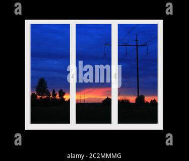 Finestre in plastica che si affacciano sullo splendido tramonto di cremisi. Vista dalla finestra principale al tramonto Foto Stock