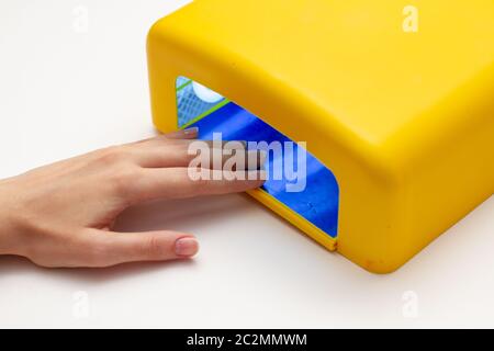 manicure processo in lampada, donne mano Foto Stock