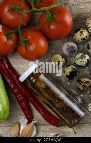 Posando gli ortaggi sulla tavola, la composizione è composta da uova di quaglia, pomodori, zucchine, spinaci e olio d'oliva con spezie, tutti i piedi sul woode Foto Stock