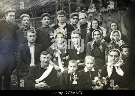 Foto d'epoca di un gruppo di persone in matrimonio. Fotografia in bianco e nero di sposi novelli con peopl Foto Stock