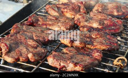 Grigliate al fuoco. Processo di cottura della carne. Bistecca sul barbecue. Preparazione di maiale appetitoso o Foto Stock