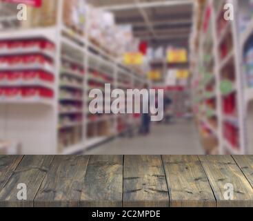 Tavole di legno d'epoca con vista sugli scaffali del supermercato. Tavolo con posto per lo shopping Foto Stock