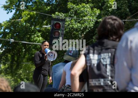 Un leader di protesta che va da J parla ai sostenitori di fronte al distretto orientale chiuso del Dipartimento di polizia di Seattle nella zona di protesta occupata da Capitol Hill a Seattle mercoledì 16 giugno 2020. La zona, una protesta di occupazione e auto-dichiarata zona autonoma, è stata istituita l'8 giugno 2020 quando il Dipartimento di polizia di Seattle ha chiuso il Precinct Est dopo giorni di proteste in seguito alla morte di George Floyd mentre si trovava nella custodia della polizia di Minneapolis. Foto Stock