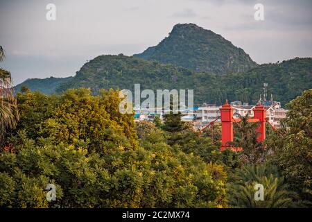 Ponte rosso su via Sanduo Lu nella città di Guilin con montagne carsiche sullo sfondo, provincia Guangxi, Cina Foto Stock