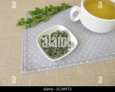 Una tazza di tè con scotch scopa Foto Stock