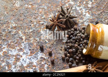 Le spezie e le erbe. Il cibo e la cucina ingredienti. Bastoncini di cannella, anice stelle, pepe nero su sfondo a trama Foto Stock