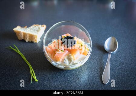 Salmone verrine ciclottero uovo formaggio fresco e letto di avocado in cucina Foto Stock