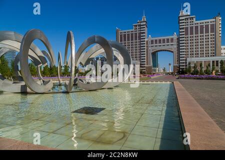 Nur-Sultan, Kazakistan - Aprile 24, 2019 - Nuovo quartiere degli affari con il traffico su strada e il parco con fontana nella capitale del Kazakistan. Ad Astana. Foto Stock