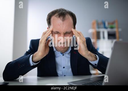 Sottolineato giovane impreditore urlando in ufficio Foto Stock