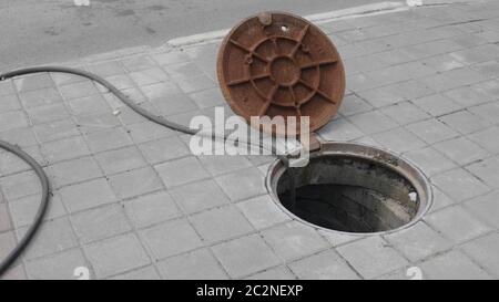 Primo piano di copertura in metallo su tombino in cemento nel cantiere Foto Stock