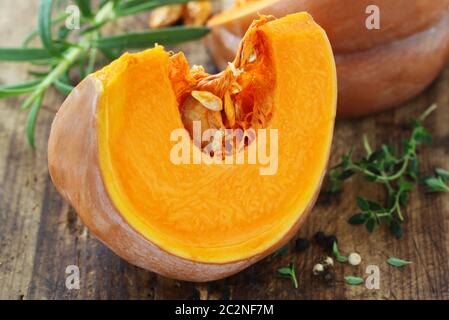 Fetta di zucca Moscato su uno sfondo di legno Foto Stock