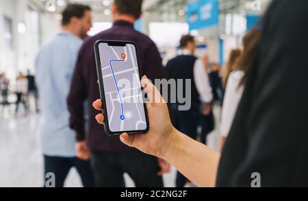 Visitatori che utilizzano l'app di navigazione mappa GPS sullo schermo dello smartphone per ottenere indicazioni per l'indirizzo di destinazione nell'immagine del concetto di città, viaggio e tecnologia Foto Stock