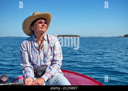 Ritratto di donna anziana sulla barca contro il mare Adriatico blu chiaro Foto Stock