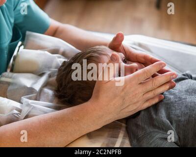 Osteopata reale non fisiologica terapia cranio per un bambino. Osteopatia trattamento. Foto Stock