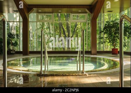 Grande vasca tonda jacuzzi nel centro termale, mattina Foto Stock