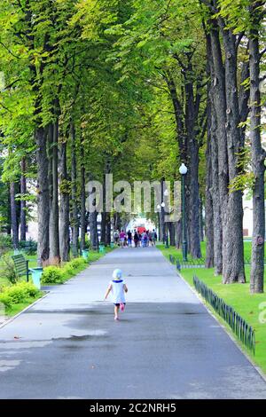 Bambina che corre nel parco cittadino. Baby walking da solo in bellissimo parco estivo Foto Stock