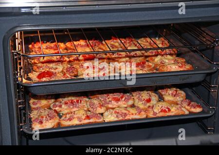 Deliziosi panini caldi sono cucinati nel forno su badge. Panini caldi con salsiccia Foto Stock