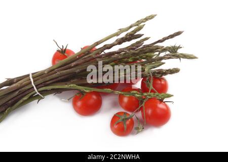 mazzo di asparagi selvatici con pomodori ciliegini Foto Stock