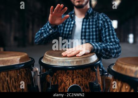 Il batterista mani giocando sul tamburo di legno, primo piano. Bongo, musicale strumento a percussione, musica etnica Foto Stock