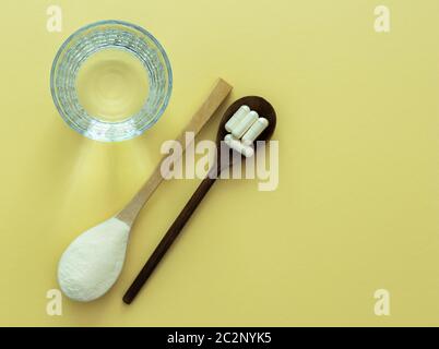 Bellezza naturale e supplemento per la salute per pelle, ossa e articolazioni. Polvere di collagene e pillole con un bicchiere d'acqua. Foto Stock