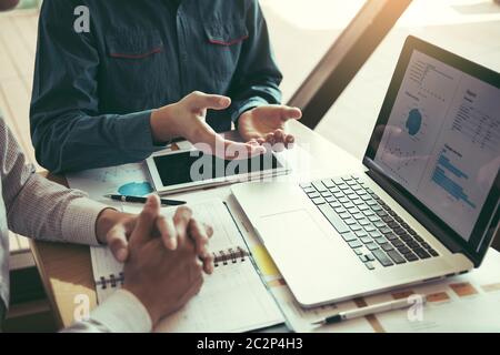 Il responsabile è seduto per spiegare il costo delle vendite dei prodotti e analizzare insieme i risultati operativi dell'azienda in ufficio. Foto Stock