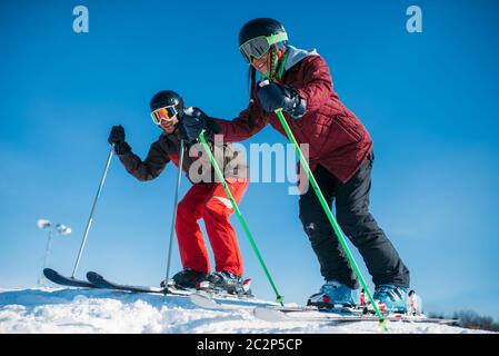 Maschio e femmina racing gli sciatori dalla montagna, vista laterale. Inverno attivo sport e stile di vita estreme. Sci di discesa Foto Stock