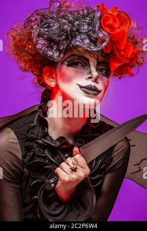 Un closeup di un clown scarier femmina coltello di tenuta Foto Stock