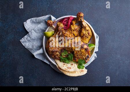 Pollo tandoori marinato in tikka servito con riso naan, lime e coriandolo. Cucina indiana, antipasto tikka. Sfondo blu con spazio per la copia Foto Stock
