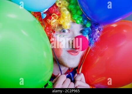 Clown sorridente con un mazzo di palloncini colorati. Concetto di circo umoristico Foto Stock