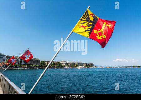 La bandiera di Ginevra ondeggia orgogliosamente contro un cielo azzurro limpido in Svizzera Foto Stock