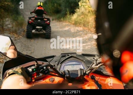 Atv riding in azione, vista attraverso gli occhi del conducente. Due piloti sul quad bikes avente offroad avventura nella foresta Foto Stock