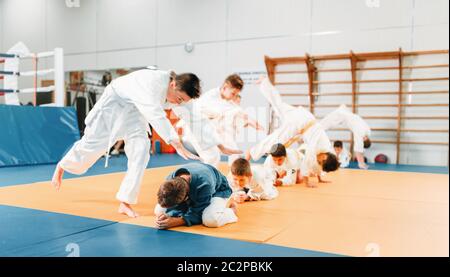 Kid judo, bambini in kimono formazione arte marziale nella hall. Bambini e bambine in uniforme, giovani combattenti Foto Stock