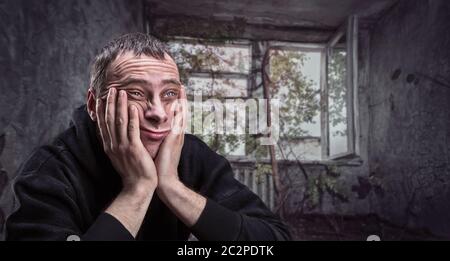 Premuto l uomo con le palme sulle guance pensa in un ghetto vecchio appartamento Foto Stock