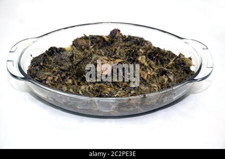 Ghormeh deriva dal kavurmak turco e significa brasato, mentre sabzi è la parola persiana per le erbe . Ghormeh sabzi vetro lastra di sfondo bianco . Foto Stock