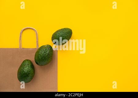 Borsa di carta marrone ecologica della drogheria con avocados.Vegetarianism. Concetto di shopping e stile di vita salutare eco-friendly. Disposizione piatta. Foto Stock