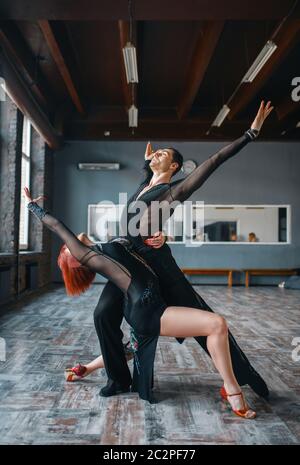 Due eleganza ballerini in costumi su ballrom danza di formazione in classe. Maschi e femmine di partner professionali sulla coppia danzante in studio Foto Stock