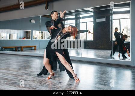 Due eleganza ballerini in costumi su ballrom danza di formazione in classe. Maschi e femmine di partner professionali sulla coppia danzante in studio Foto Stock