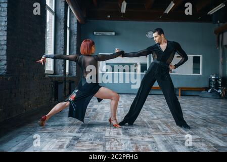 Due ballerini in costume su ballrom danza formazione in classe. Partner femminili e maschili in coppia professionale danzante in studio Foto Stock