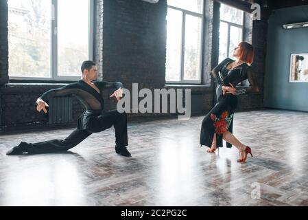 L uomo e la donna sulla ballrom danza di formazione in classe. Maschi e femmine di partner professionali sulla coppia danzante in studio Foto Stock