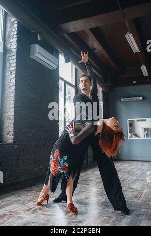 L uomo e la donna sulla ballrom danza di formazione in classe. Maschi e femmine di partner professionali sulla coppia danzante in studio Foto Stock