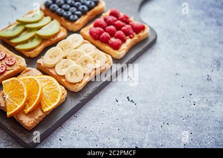 Cereali integrali fette di pane con burro di arachidi e frutti vari Foto Stock