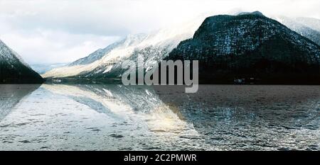 Panorama del lago Hallstatt all'aperto con montagne innevate con riflessi in acqua in Austria, nelle alpi austriache Foto Stock