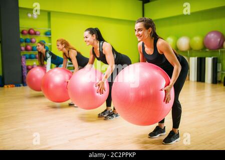 Gruppo di donne con le palle grandi che fanno l'esercitazione, l'allenamento di idoneità. Lavoro di squadra femminile in palestra. Classe di idoneità, aerobica Foto Stock