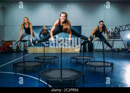 Gruppo di donne su trampolino sportivo, allenamento fitness. Lavoro di squadra femminile in palestra. Classe aerobica Foto Stock