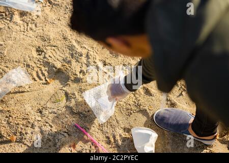 Vista dall'alto di volontari che proteggono l'ambiente e raccolgono rifiuti in spiaggia Foto Stock