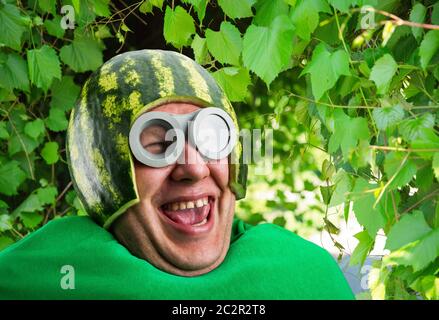 Funny Man con cocomero e casco googles assomiglia a un caterpillar parassita Foto Stock